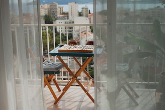 a balcony with a table and chairs and a view of a city