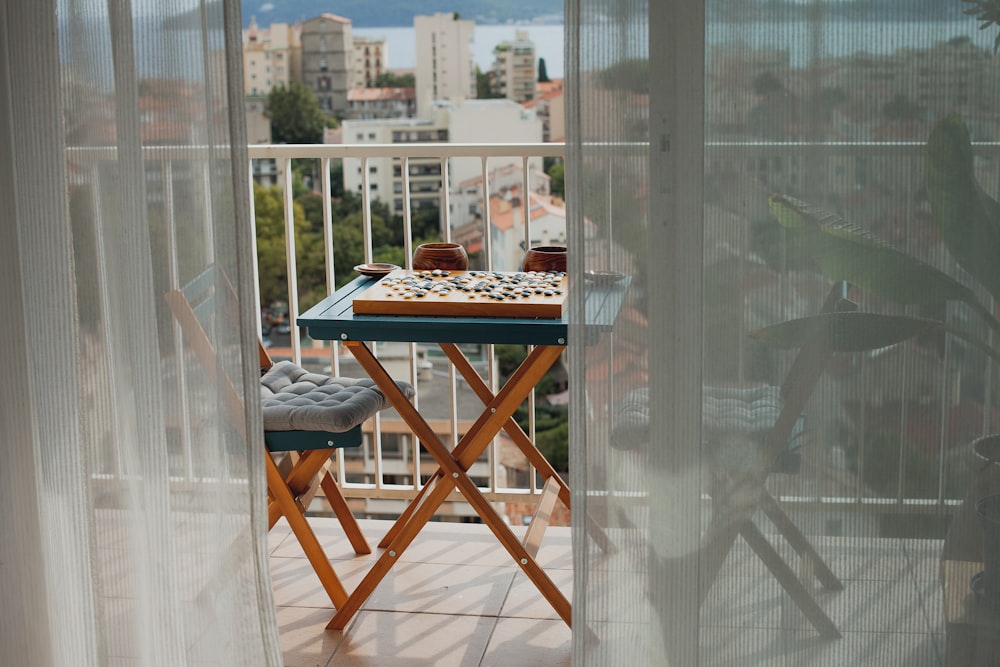 a balcony with a table and chairs and a view of a city