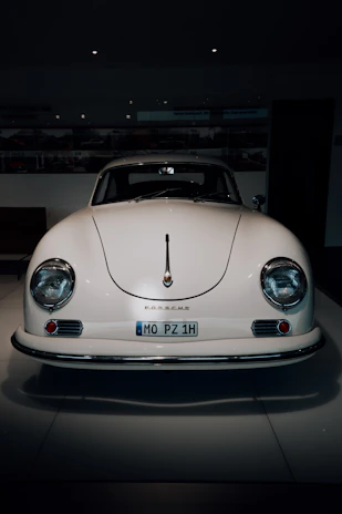 A classic vintage car in pristine condition displayed under soft showroom lighting.