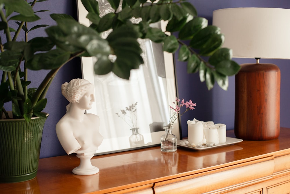 a table with a mirror and a vase with flowers on it