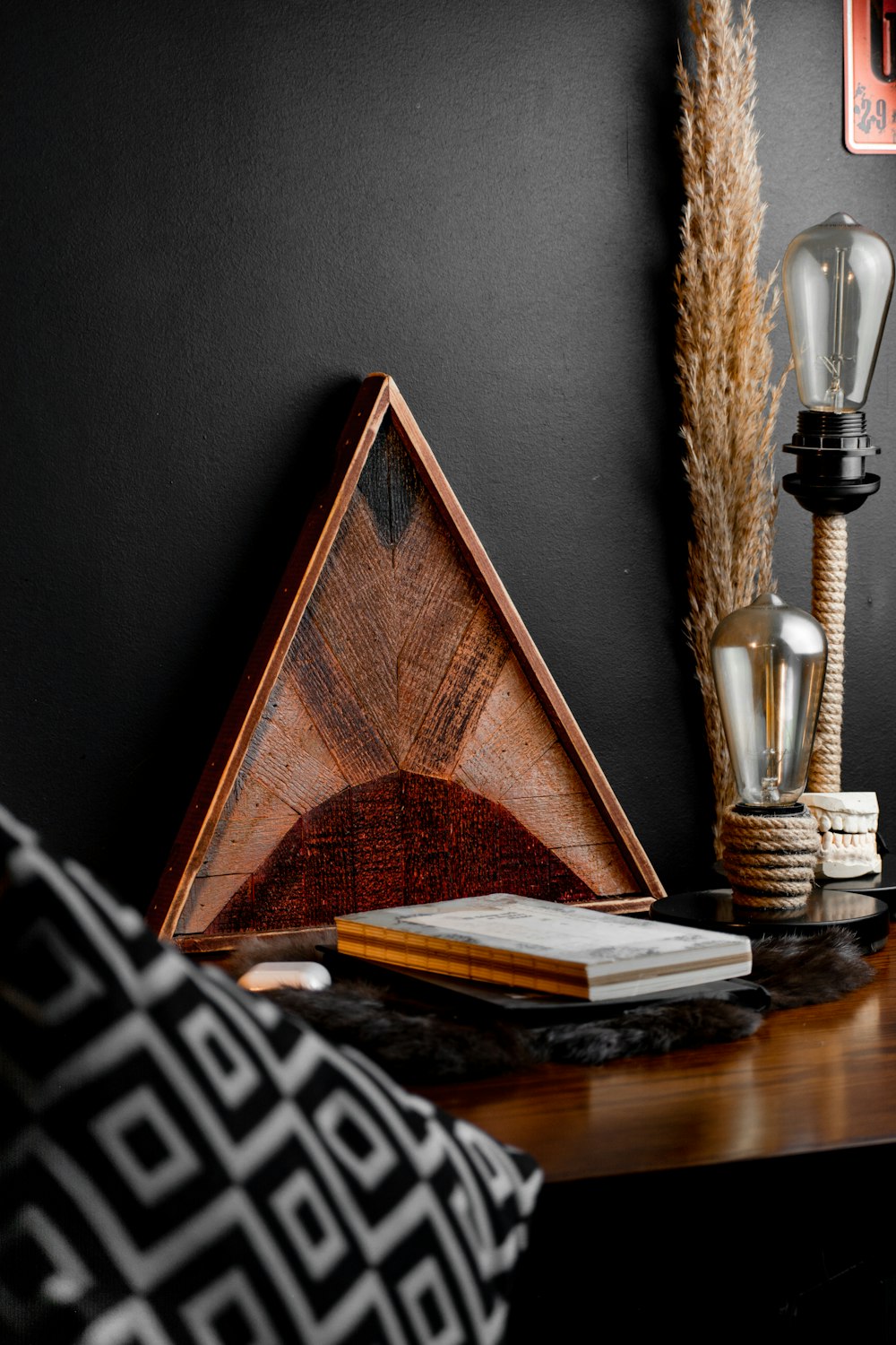 a wooden table topped with a lamp and a book