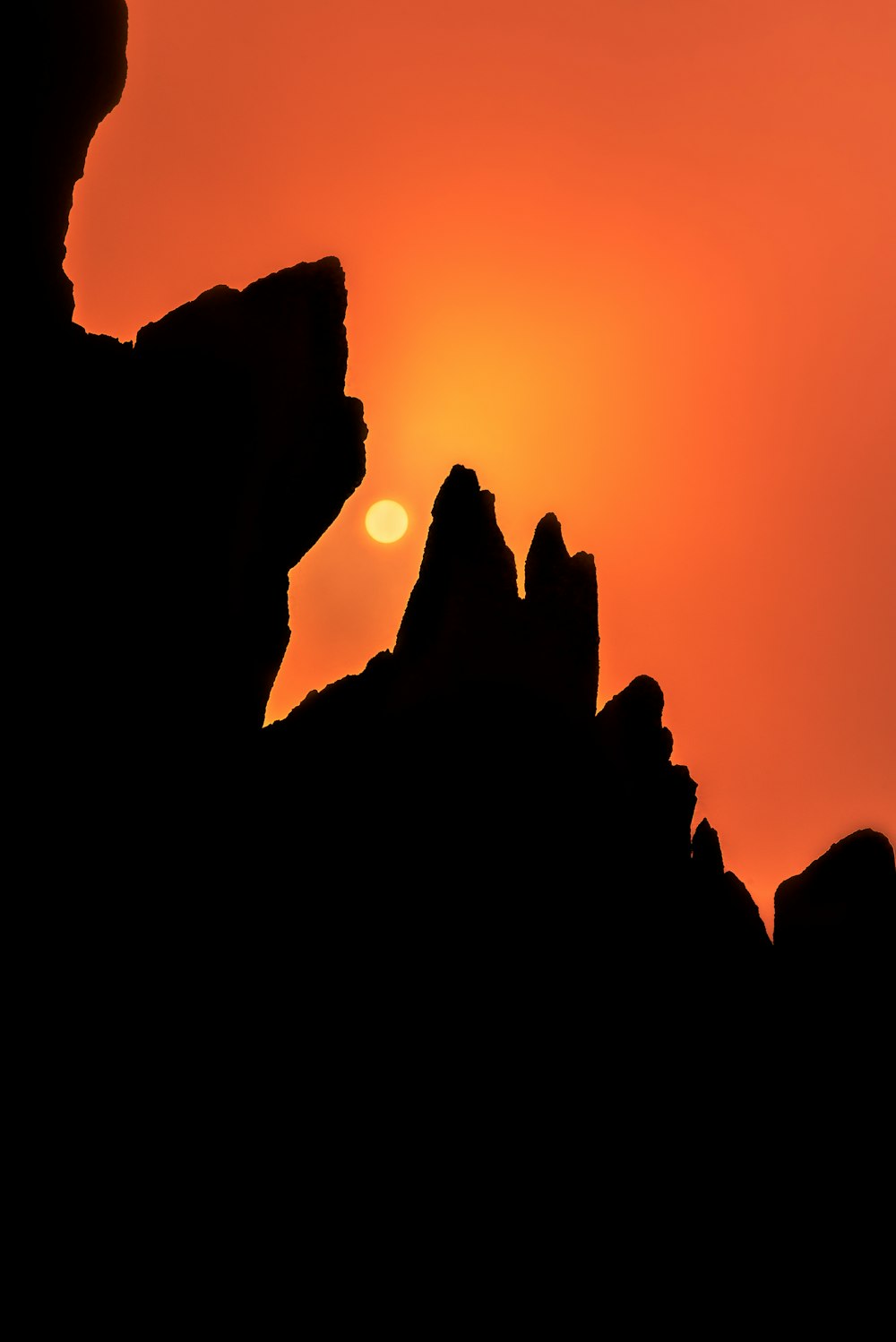 the sun is setting over a rocky outcropping