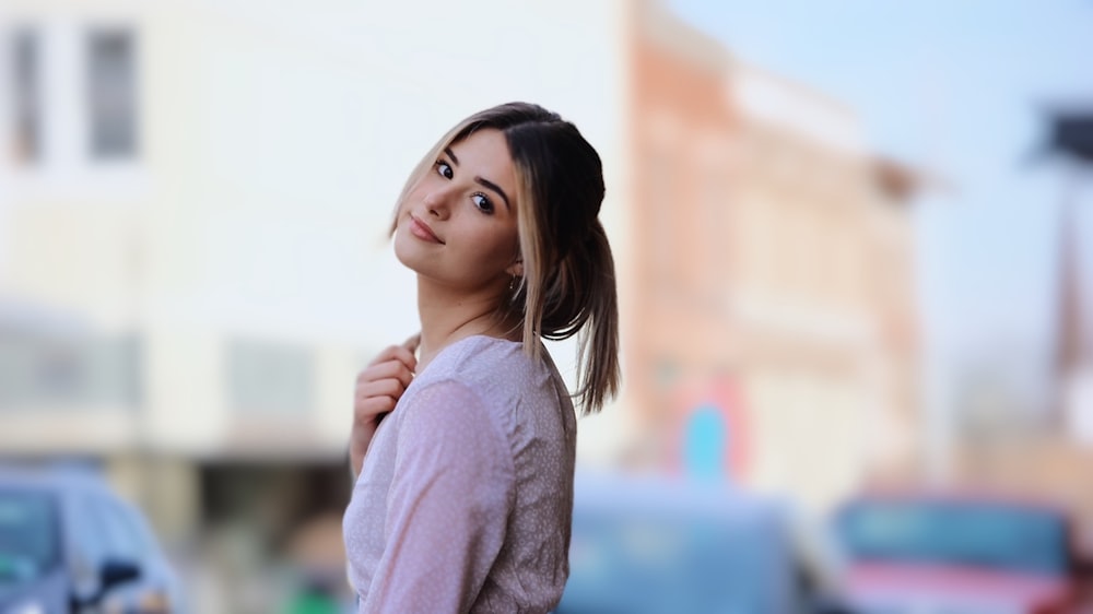 a woman standing in front of a car looking up