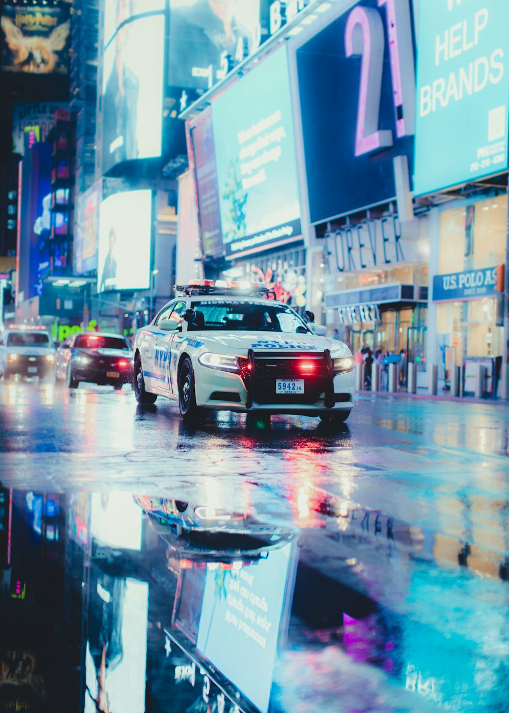 a police car driving down a street next to tall buildings