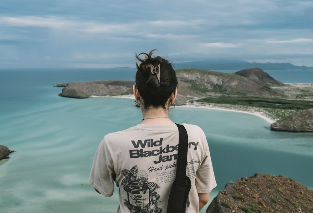 Una donna in piedi sulla cima di una scogliera vicino all'oceano