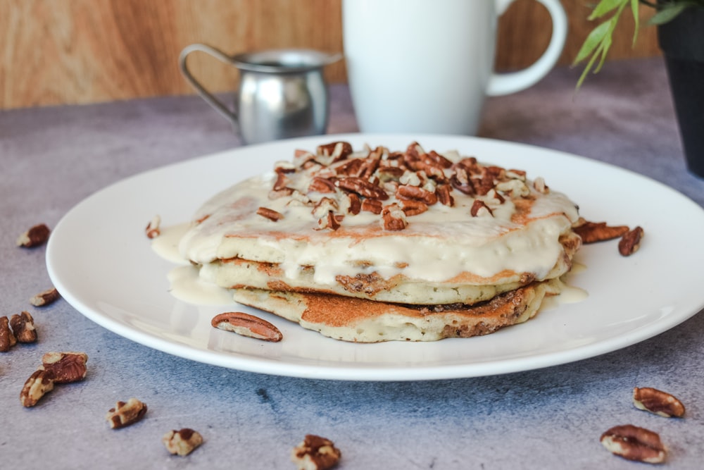 a white plate topped with pancakes covered in frosting