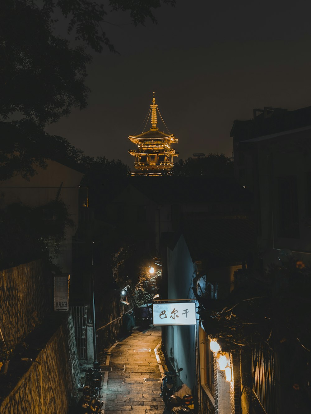 a city street at night with a clock tower in the background