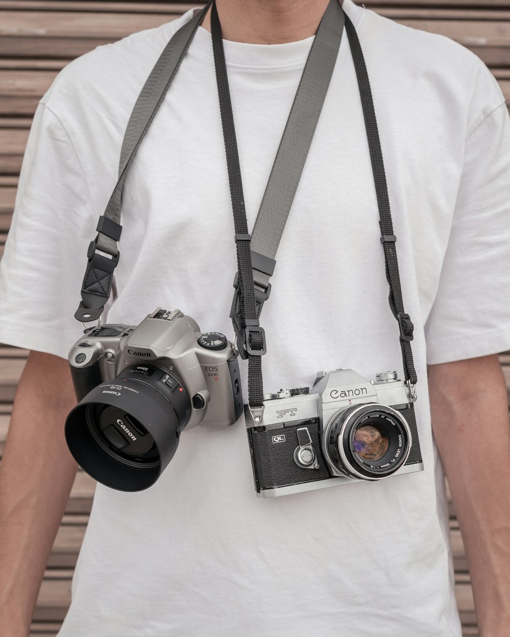 a man wearing a camera strap and holding a camera