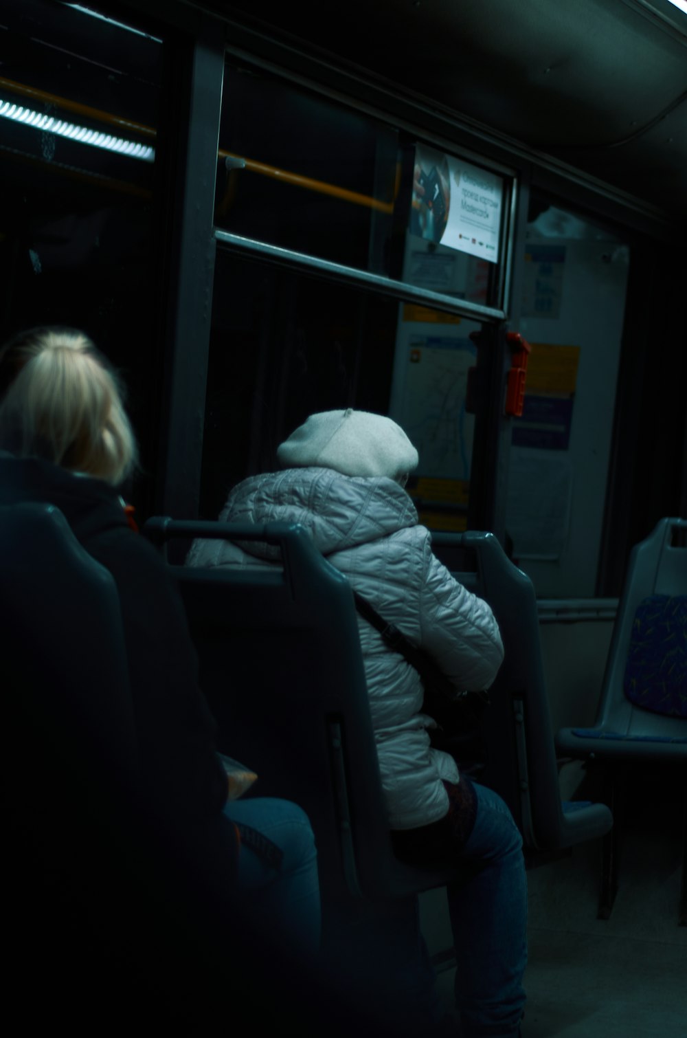 two people sitting on a bus at night