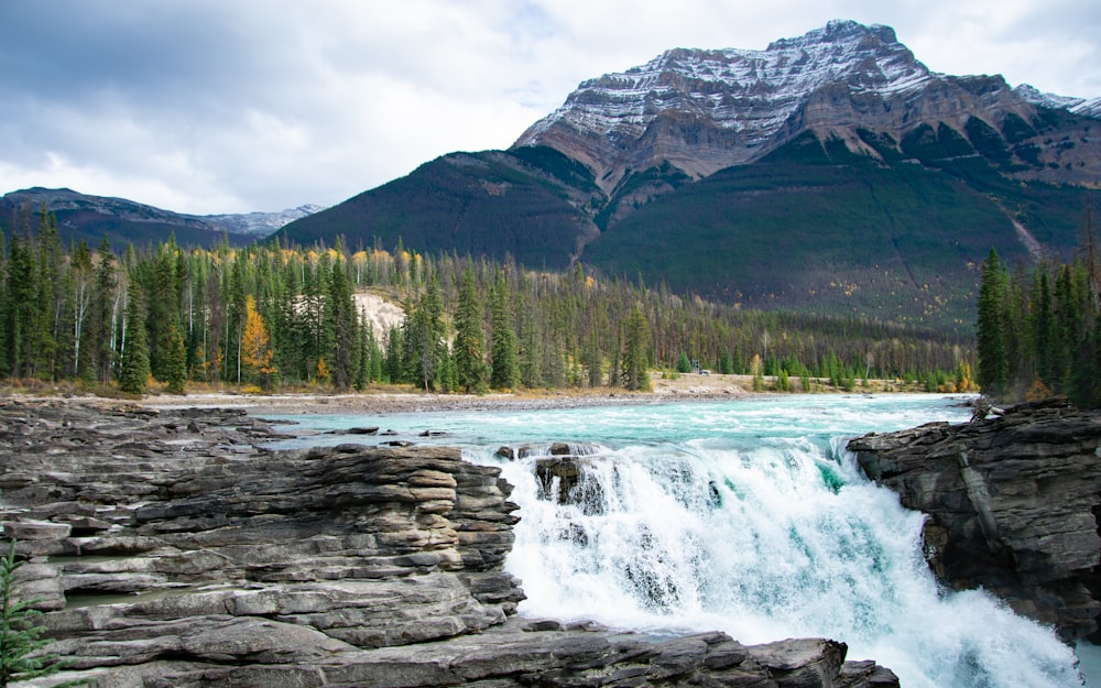 a waterfall with a mountain in the background