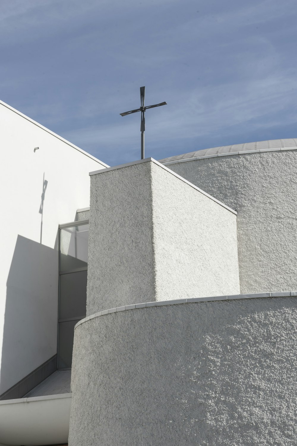 a cross on top of a white building