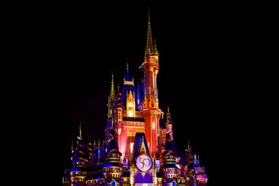 a castle lit up at night with a clock