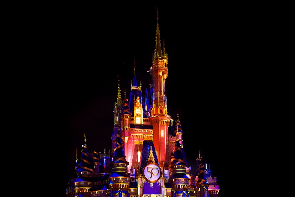 a castle lit up at night with a clock