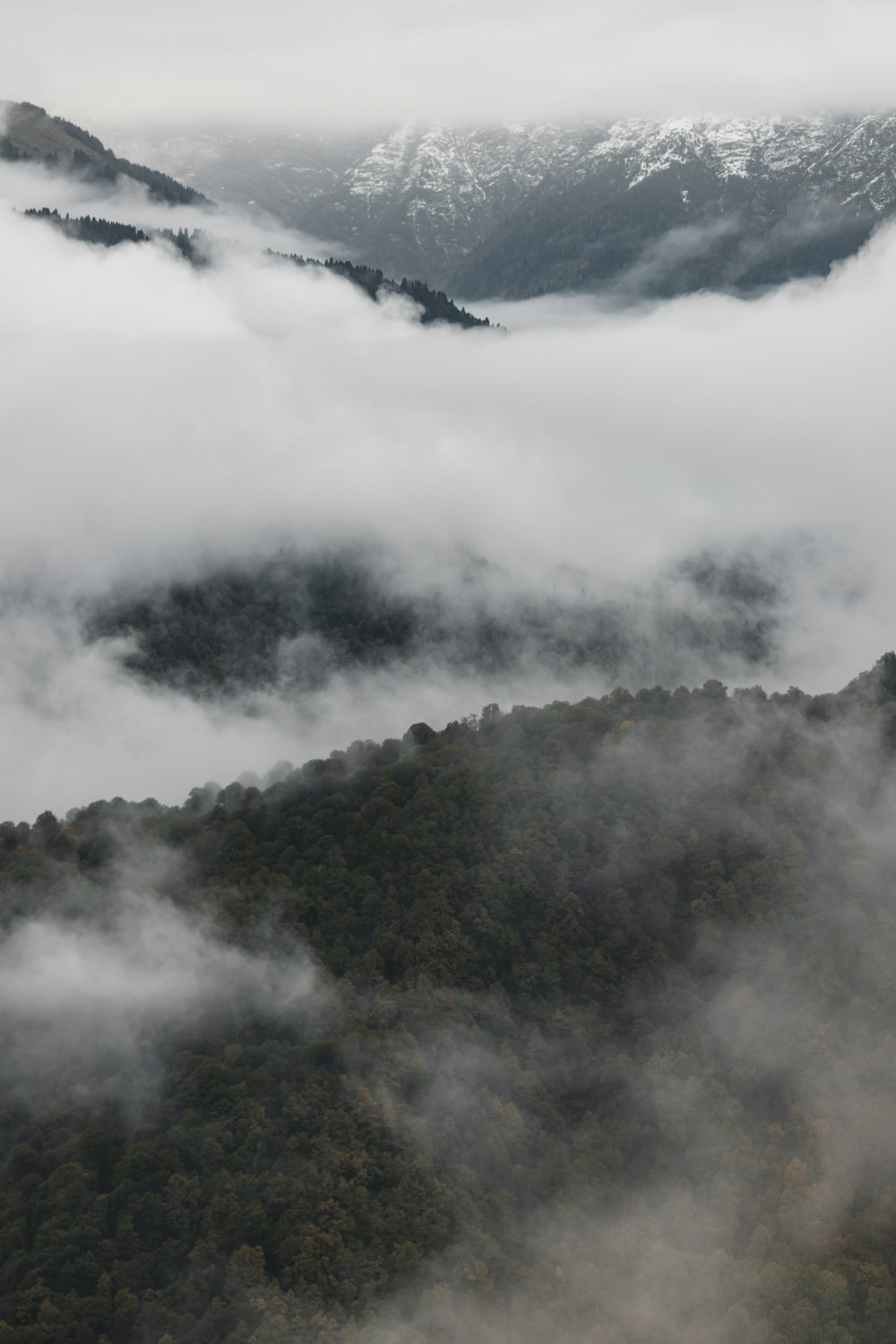 uma montanha coberta de nevoeiro e nuvens baixas