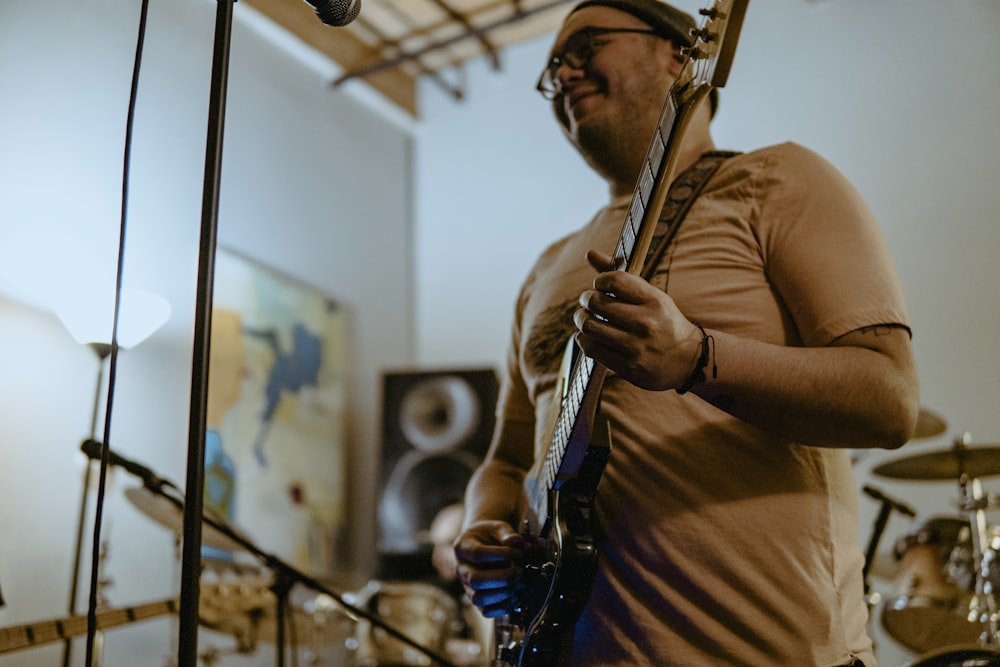 a man playing a guitar in front of a microphone