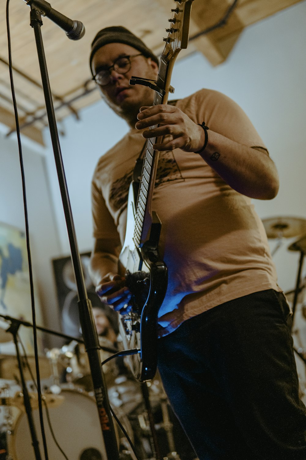 a man playing a guitar in front of a microphone