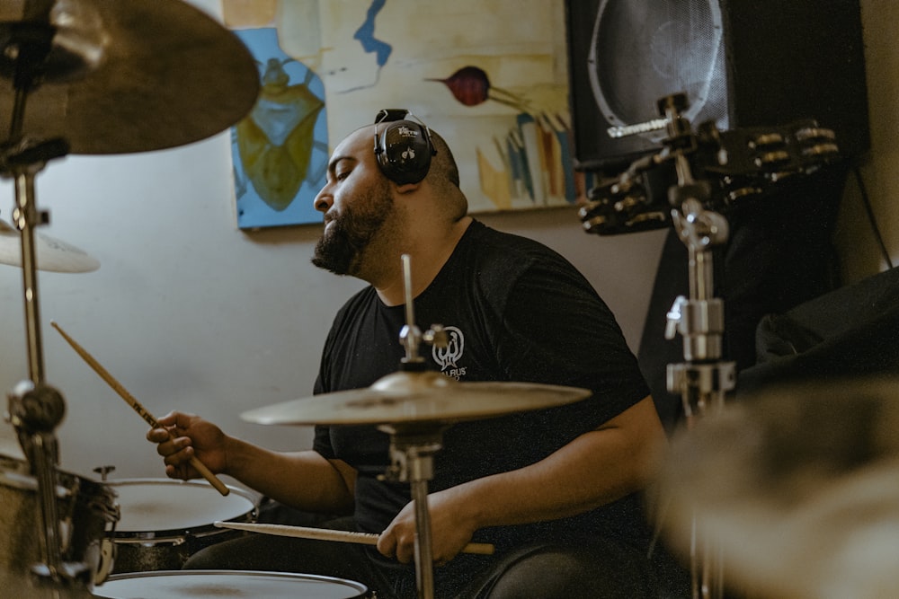 a man sitting in front of a drum set