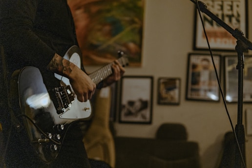 a man playing a guitar in front of a microphone