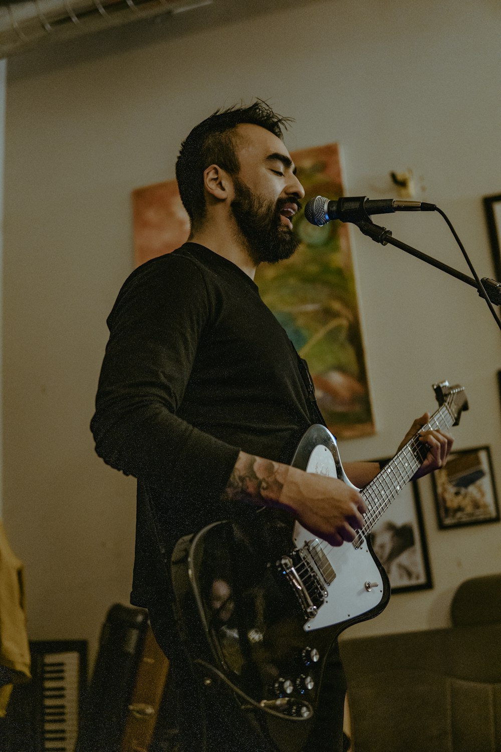 a man playing a guitar in front of a microphone