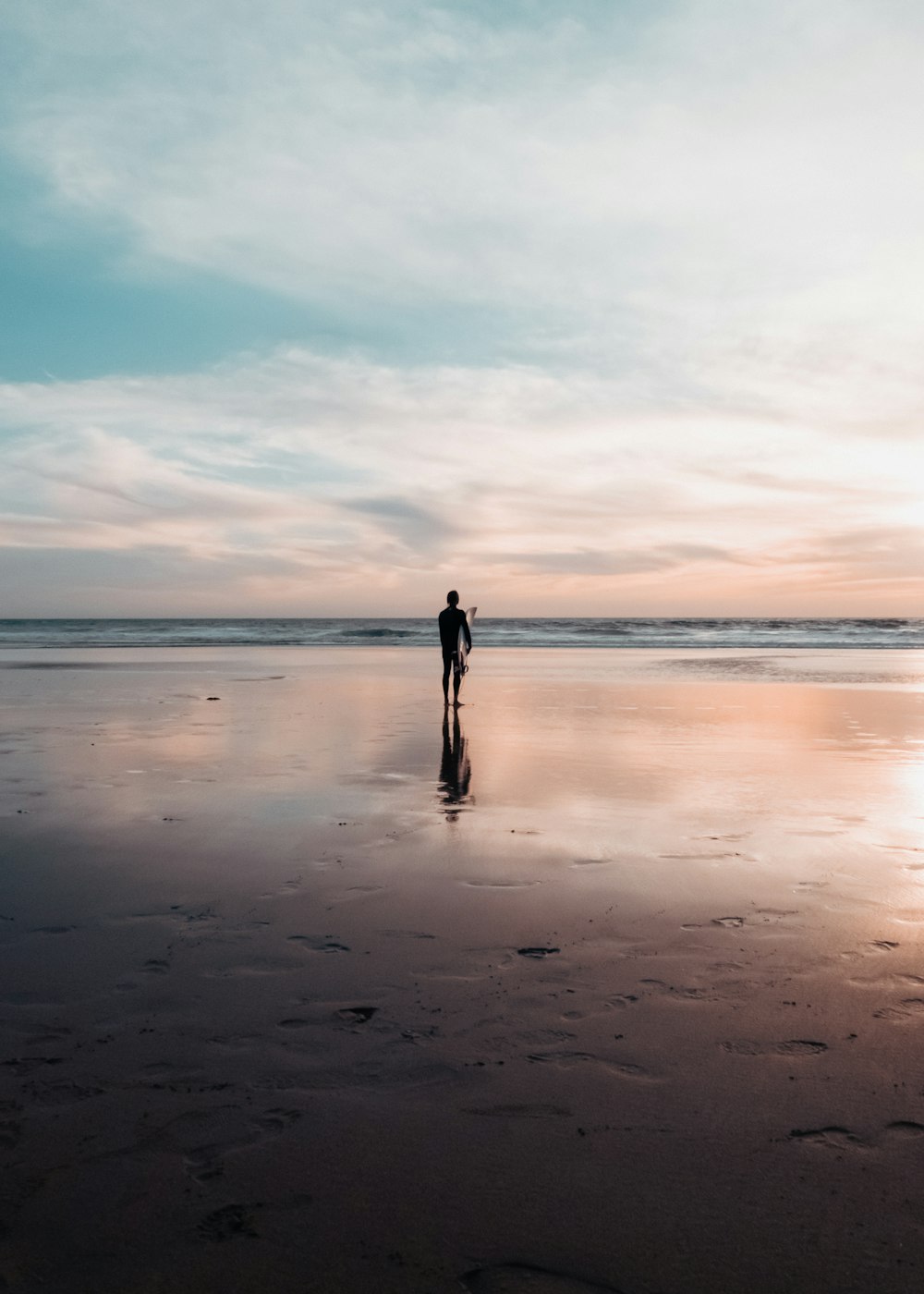 a person standing on a beach near the ocean