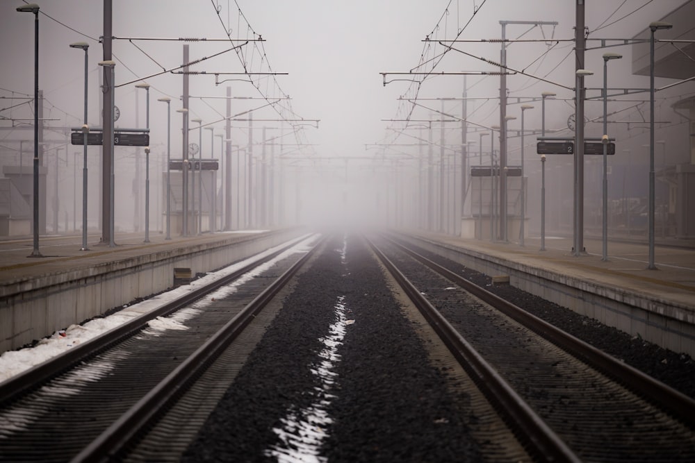 a train track with a foggy sky in the background