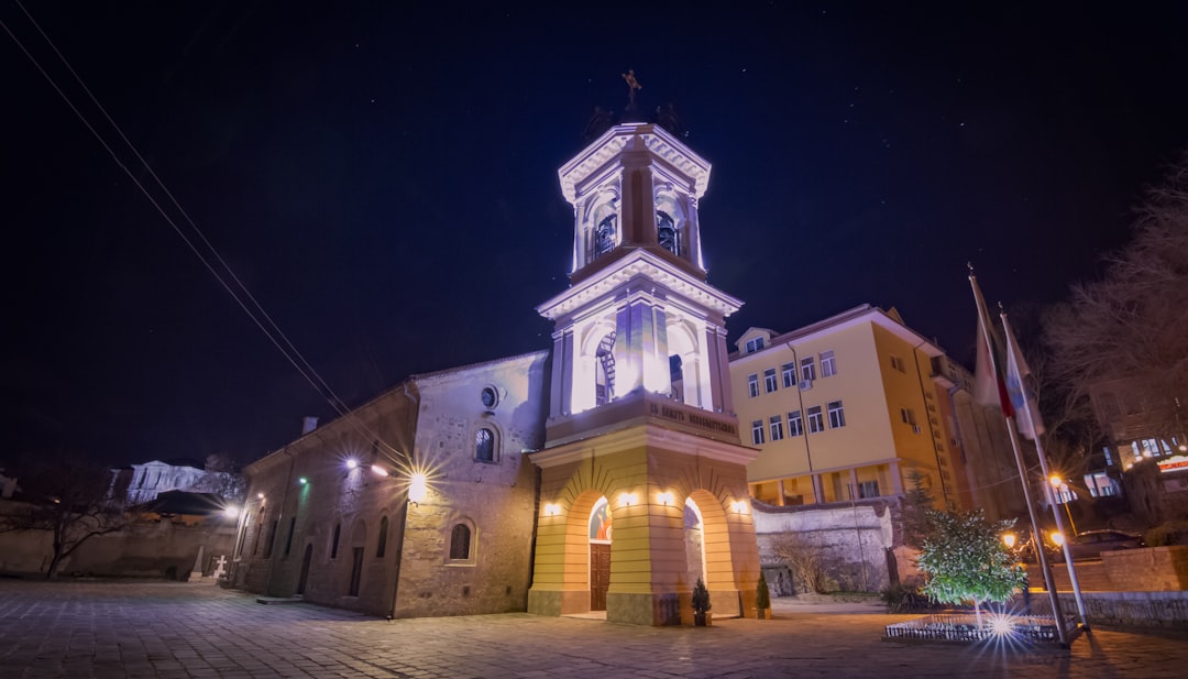 a church with a clock tower lit up at night,