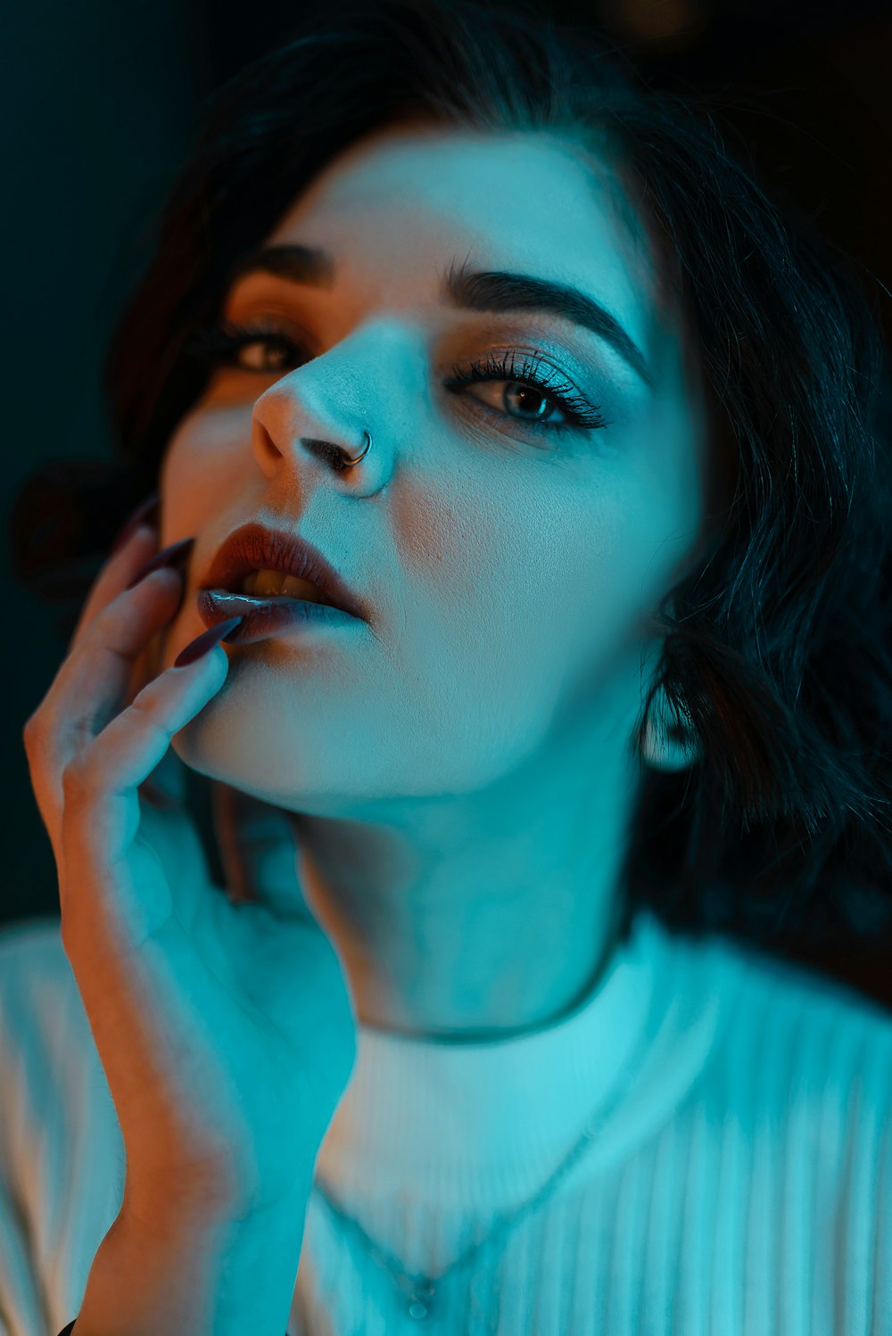 a woman in a white sweater is smoking a cigarette