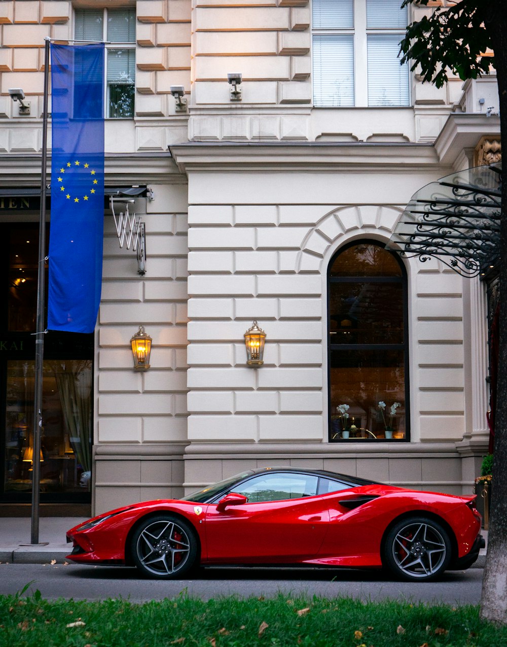 Un'auto sportiva rossa parcheggiata davanti a un edificio