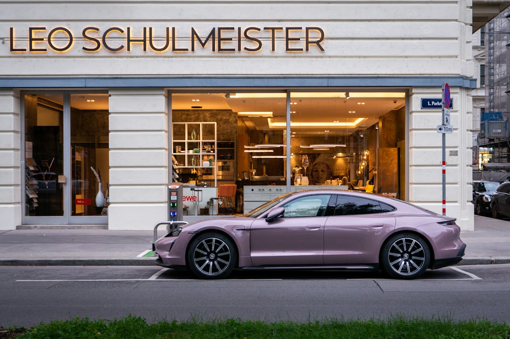 a pink car parked in front of a store