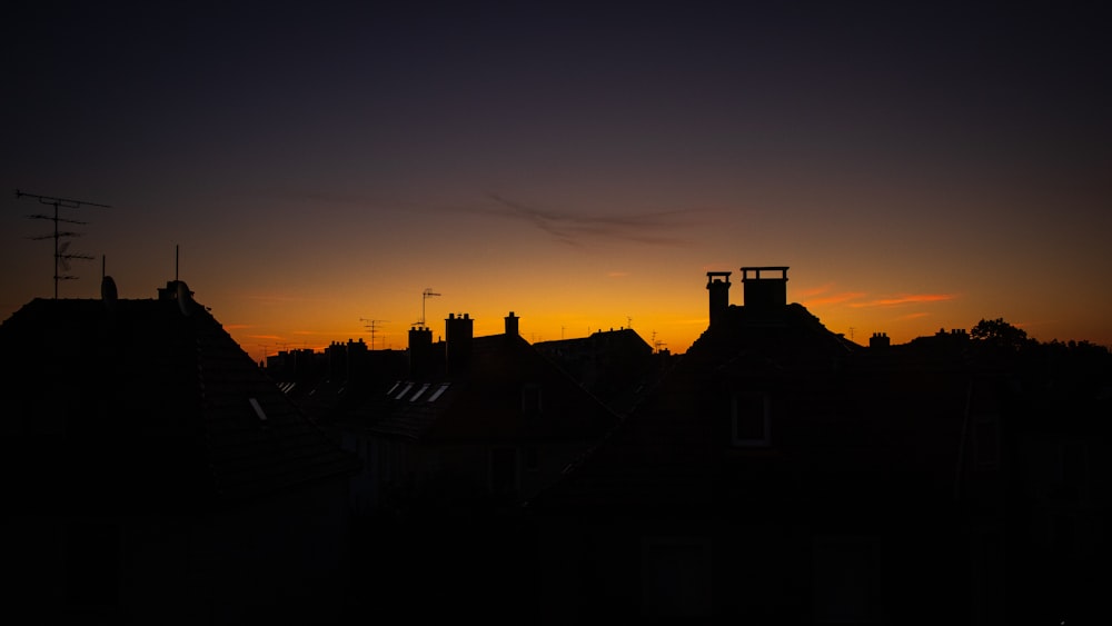 the sun is setting over a city with rooftops