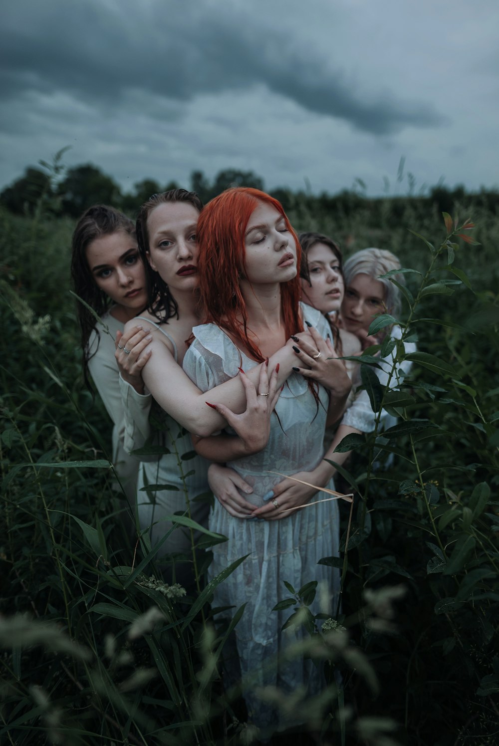 a group of women standing next to each other in a field