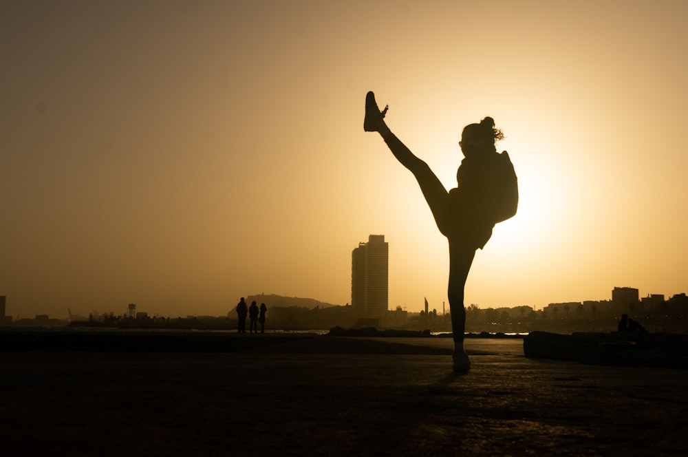 a person doing a handstand in front of the sun