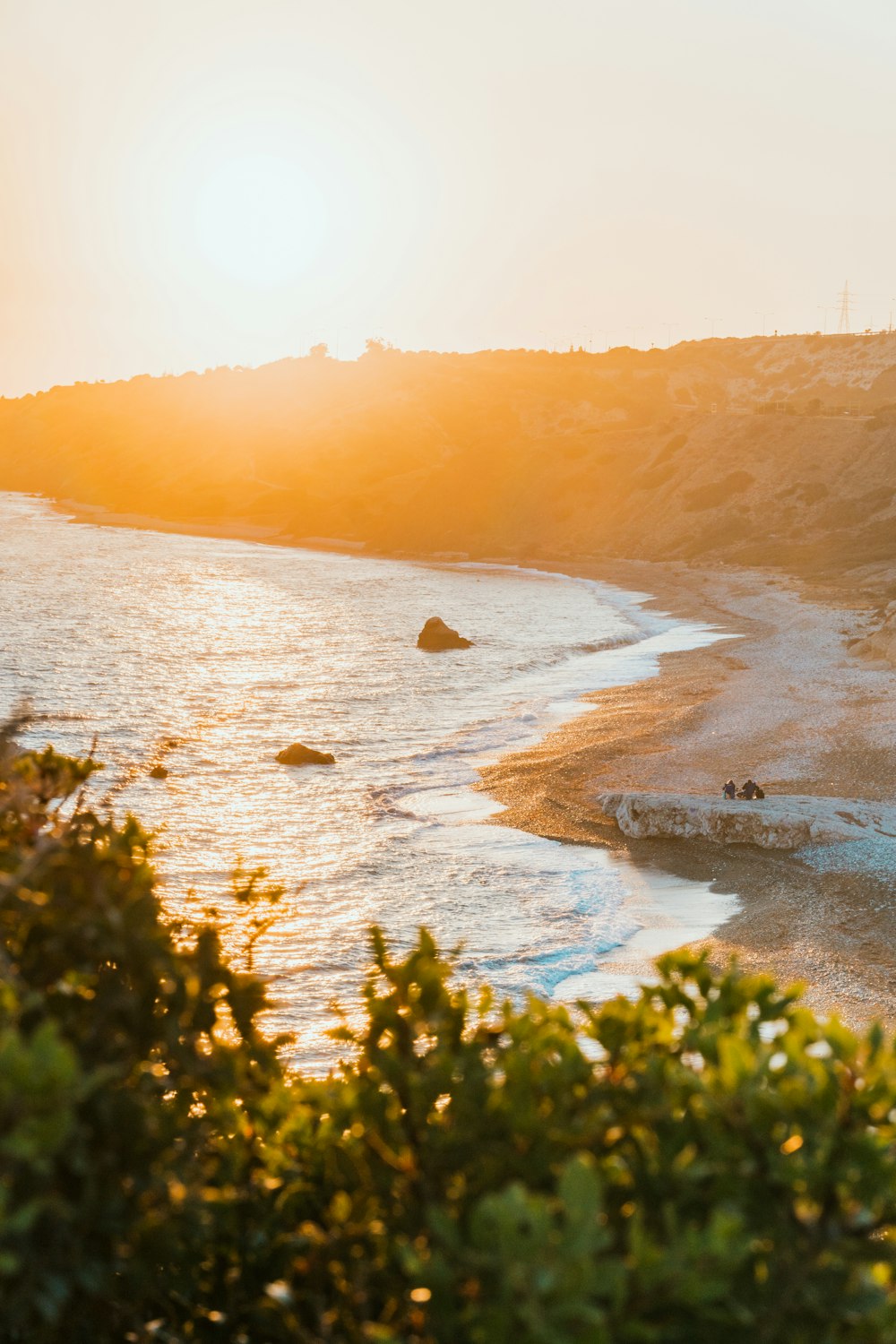 the sun is setting over the beach and the water