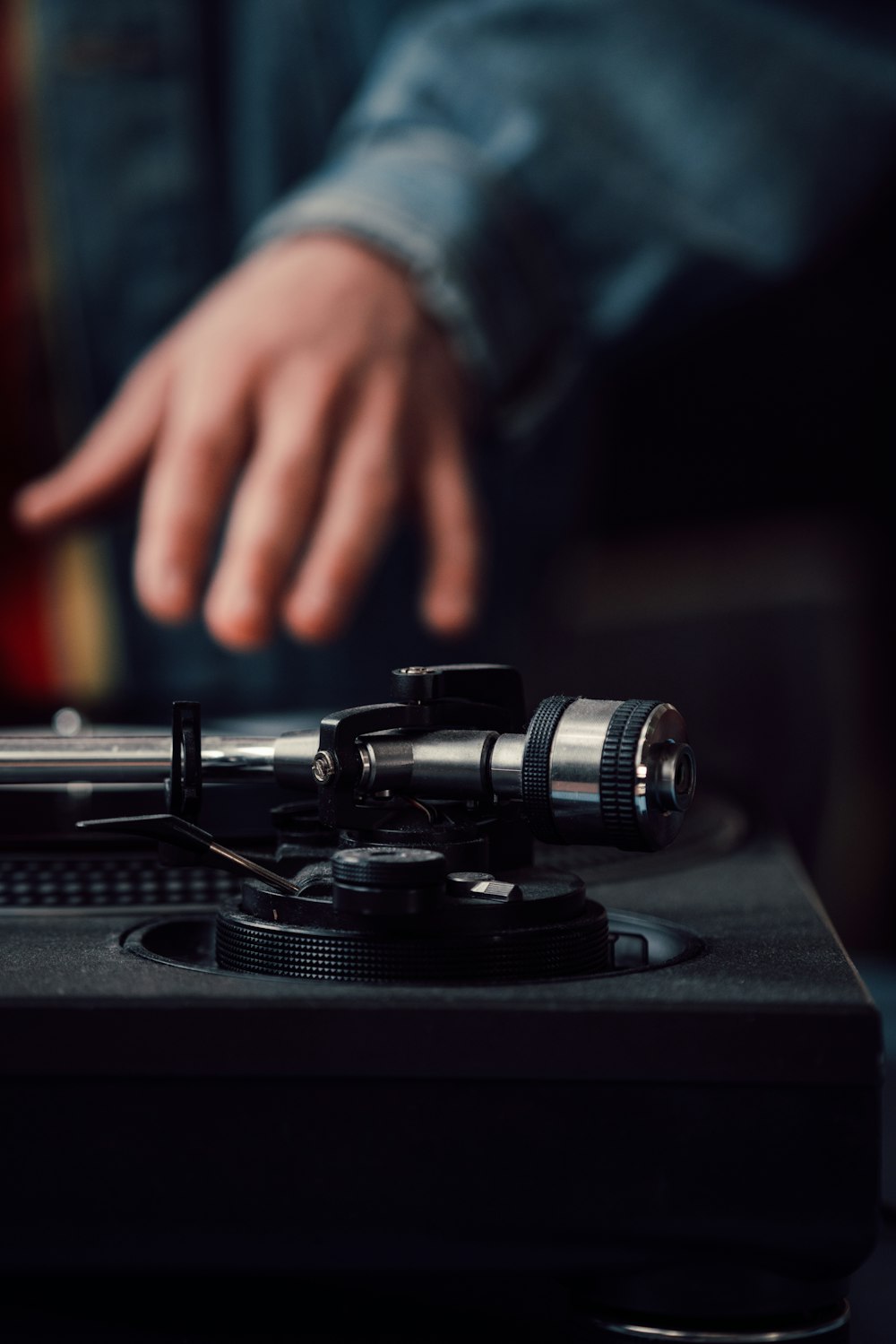 a person pointing at a record player on a turntable