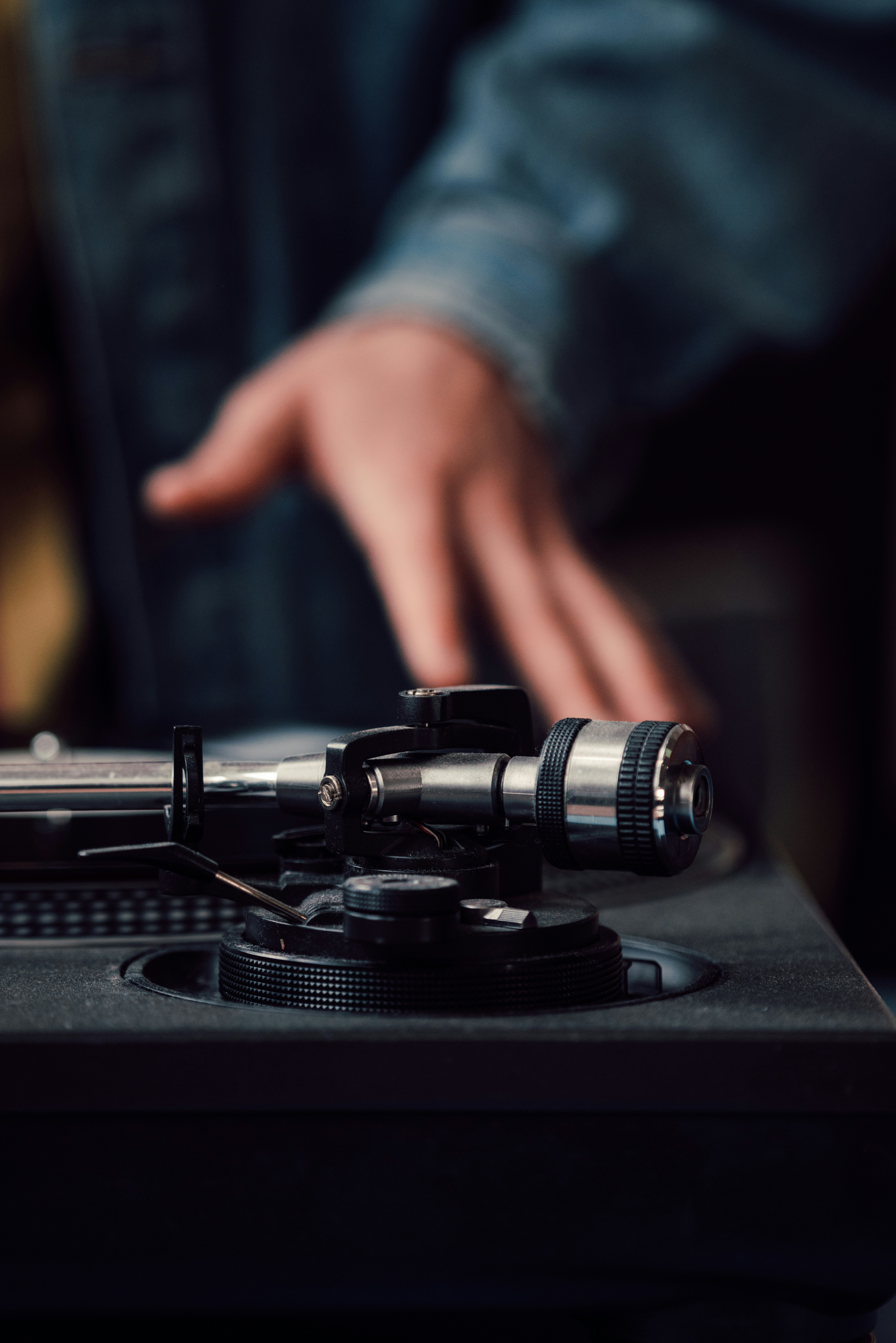 a person pointing at a record player on a turntable