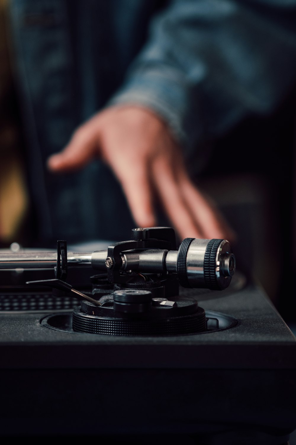 a person pointing at a record player on a turntable