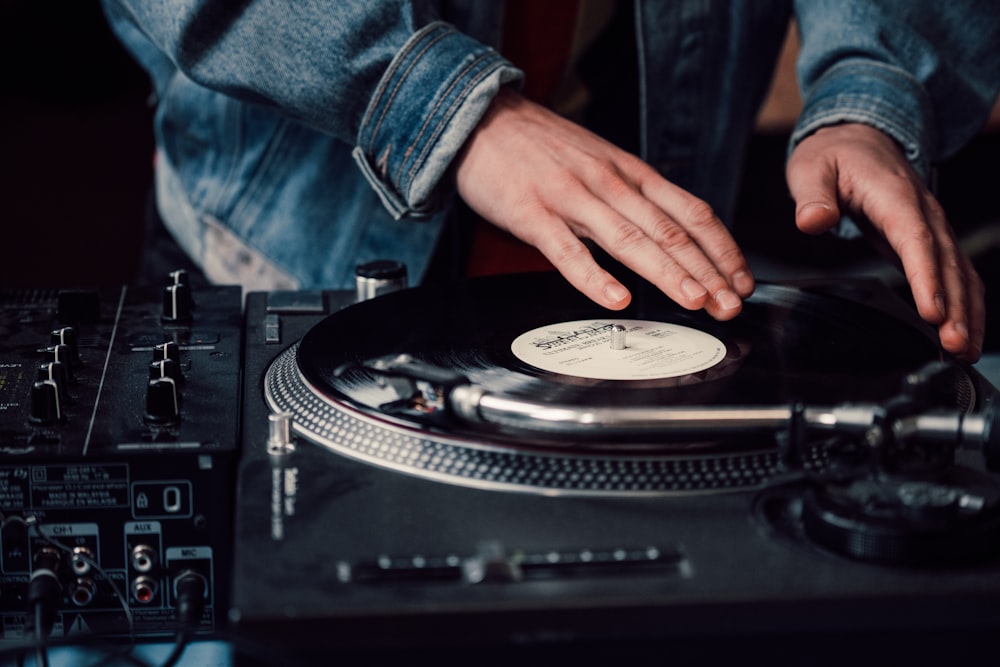 a person touching a record on a turntable