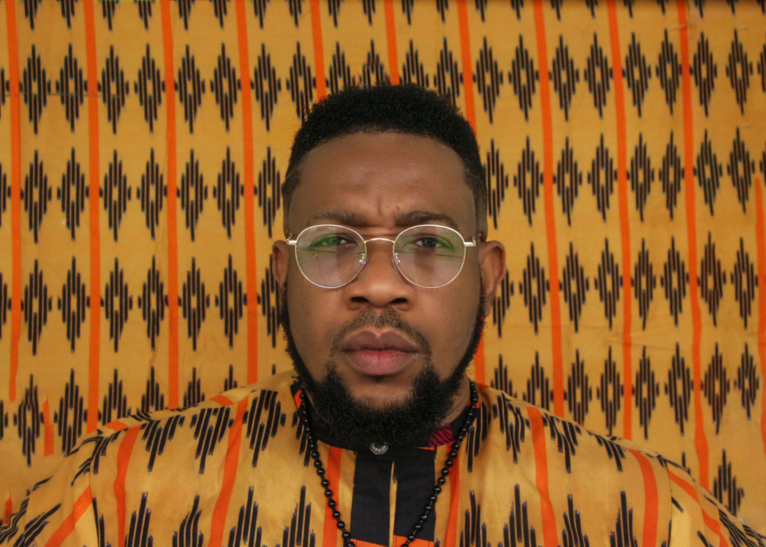 a man wearing glasses and a patterned shirt