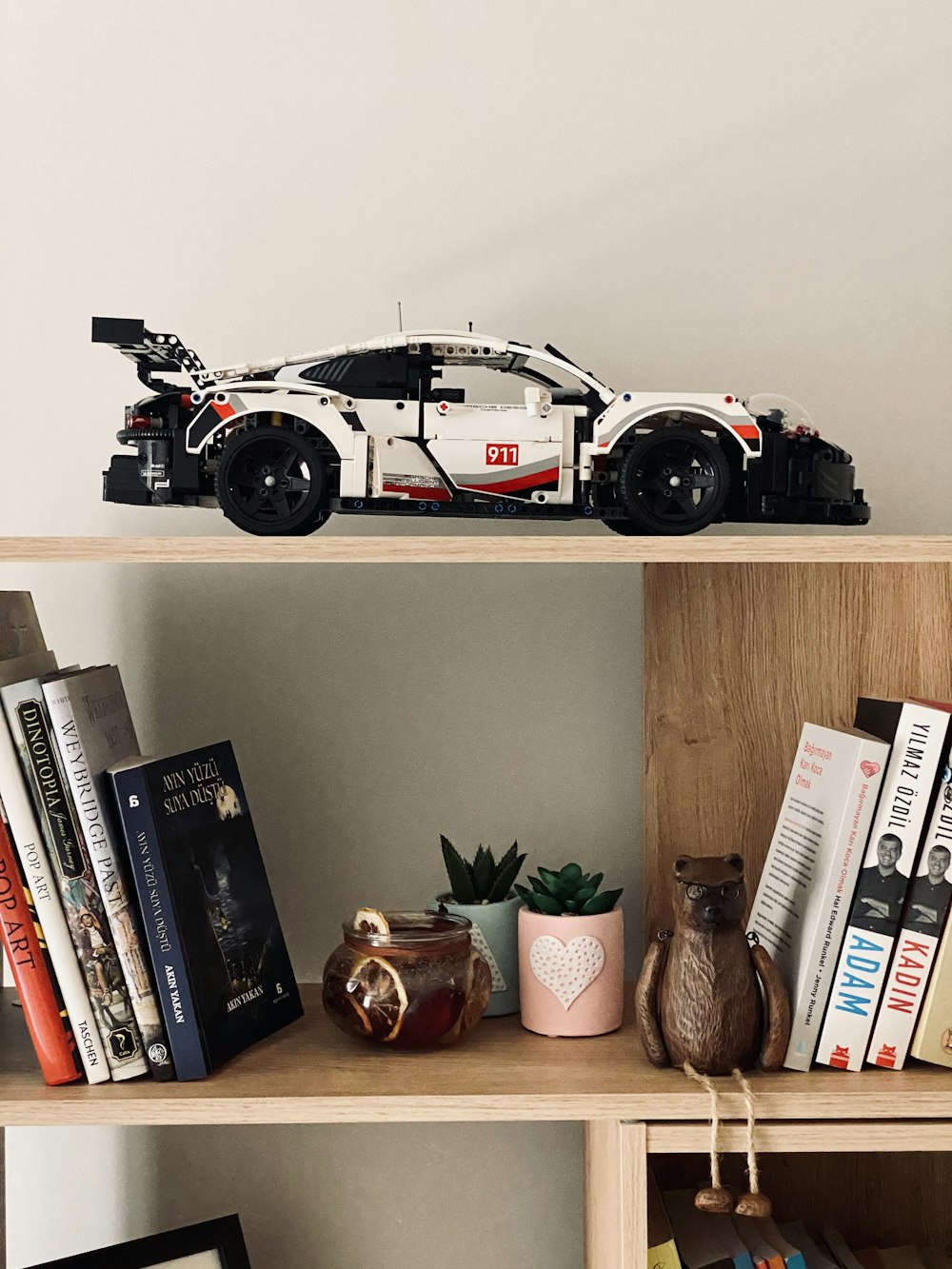 a toy car is sitting on top of a bookshelf