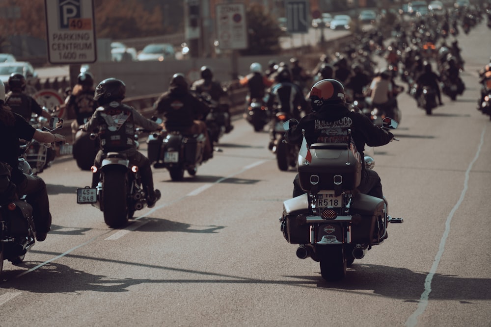 a large group of people riding motorcycles down a street
