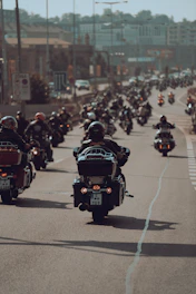 a large group of people riding motorcycles down a street