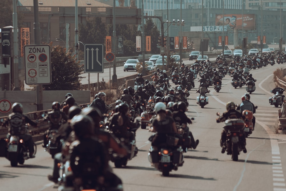 a large group of people riding motorcycles down a street