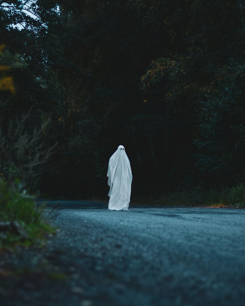 a ghost is walking down the road in the dark