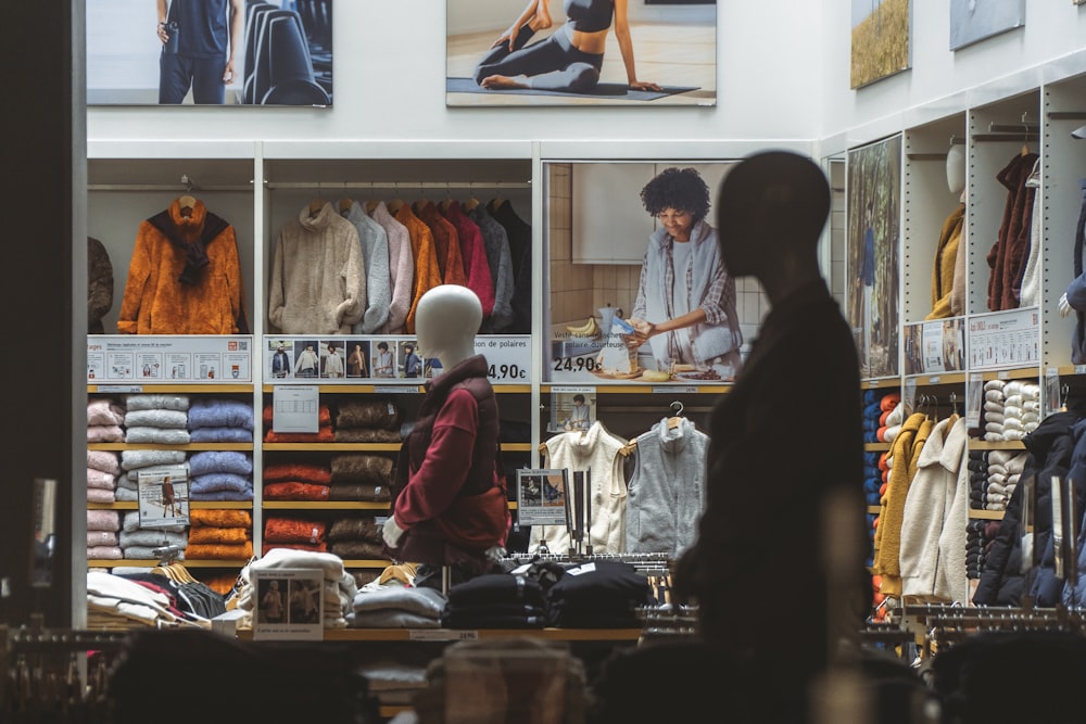 a man standing in front of a store filled with clothing