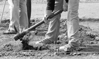 a group of people standing next to each other holding shovels