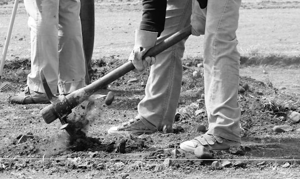 Group of miners collaborating on a steep green slope with detection equipment.