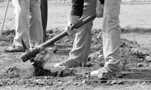 A group of Black artisanal gold miners working together at a sub-Saharan African mining site.