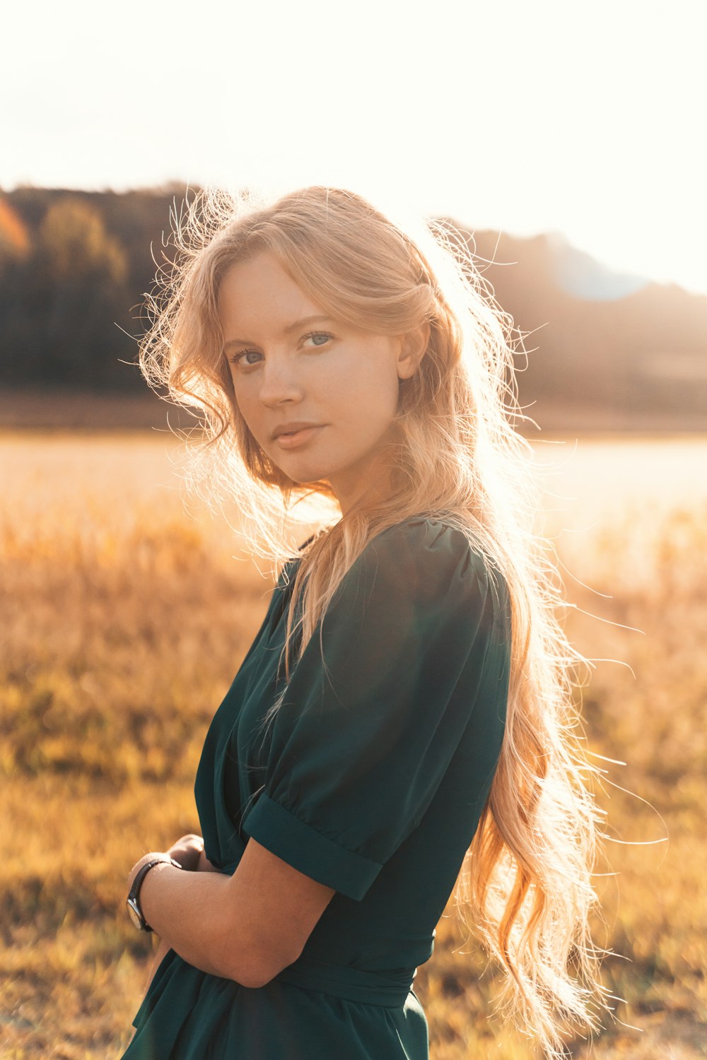 a woman in a green dress standing in a field