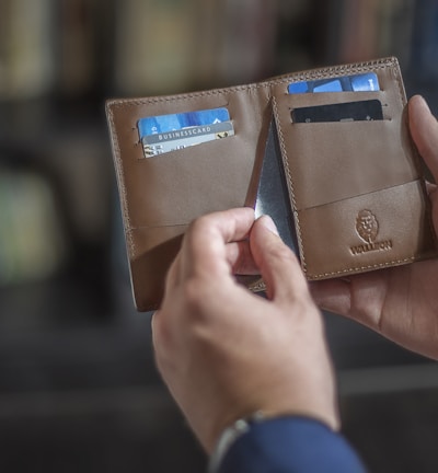 a person holding two wallets in their hands