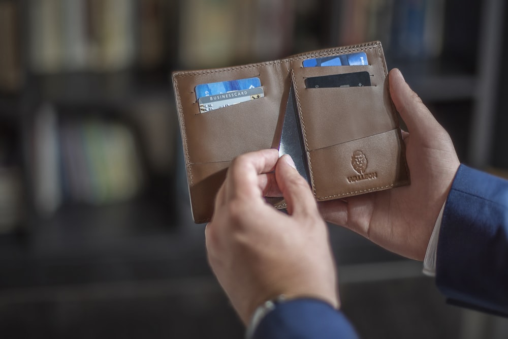 eine Person, die zwei Brieftaschen in der Hand hält